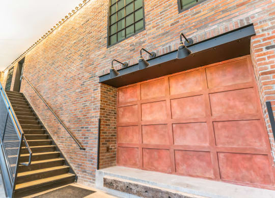 the front of a brick building with a garage door and stairs at Hawkins Press, North Carolina, 28203