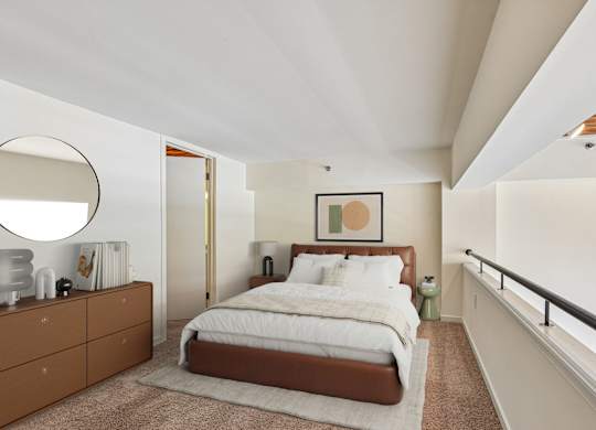 A bedroom with a large bed and a brown dresser.
