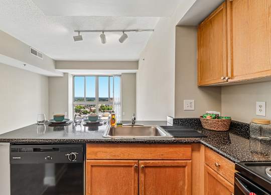 A kitchen with wooden cabinets and a black countertop.