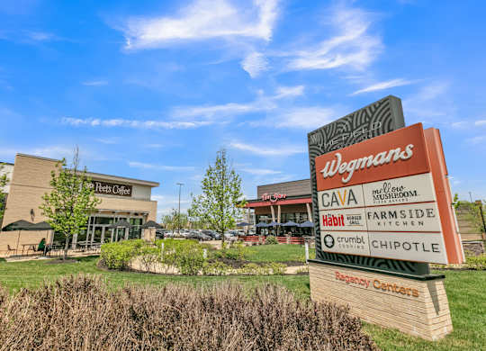 A large sign for Wegmans in front of a building. at The Sully, Virginia