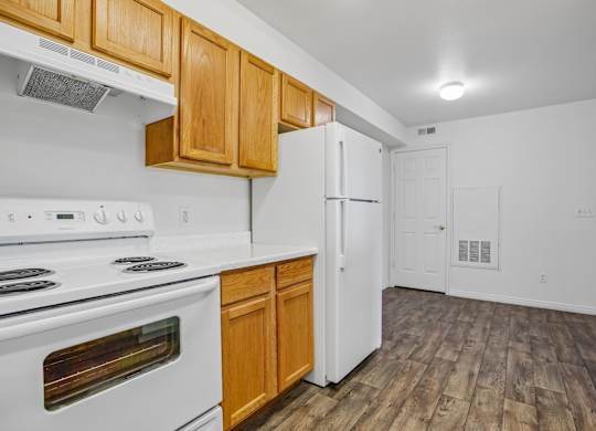 A kitchen with white appliances and wooden cabinets.