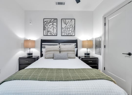 a bedroom with a large bed and two lamps