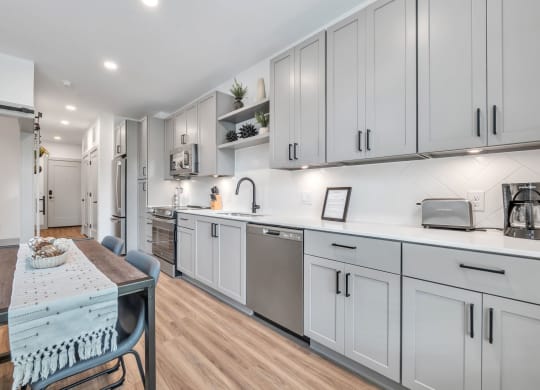a kitchen with white cabinets and a dining table