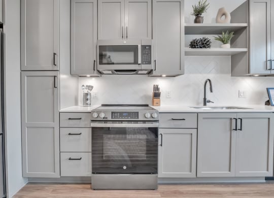 a white kitchen with stainless steel appliances and white cabinets