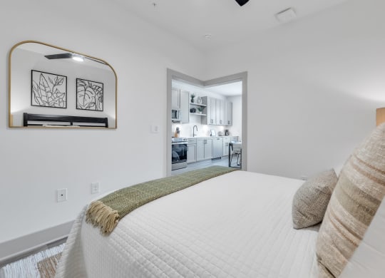 a white bedroom with a large bed and a window