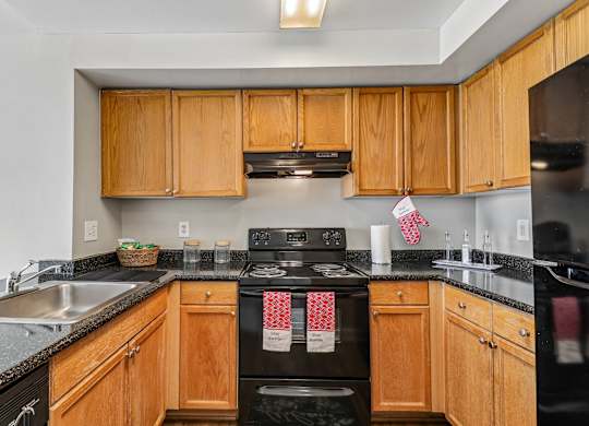 A kitchen with wooden cabinets and black appliances.