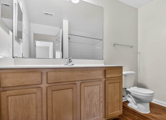 A white toilet sits next to a wooden cabinet in a bathroom.