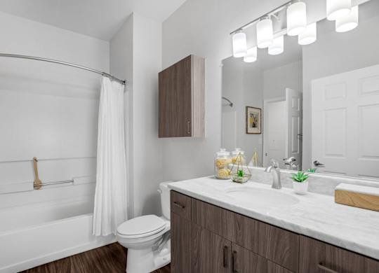 A white bathroom with a toilet, sink, and shower.