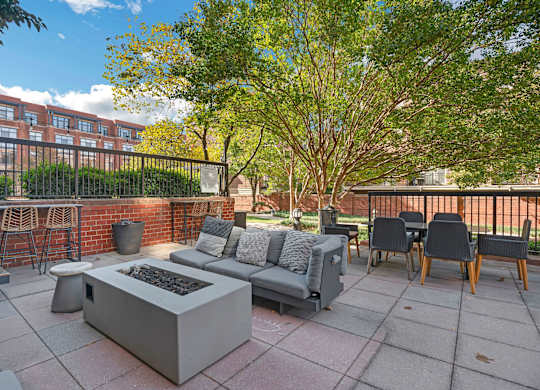 A patio with a fire pit and seating area.