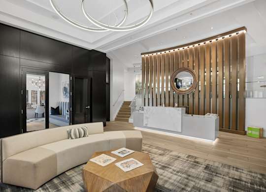 A modern living room with a wooden coffee table and a large mirror on the wall.