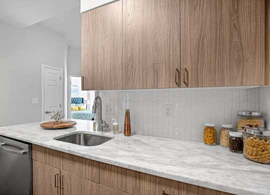 A kitchen with wooden cabinets and a marble countertop.