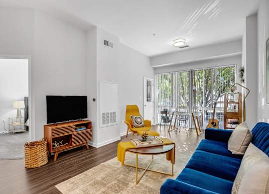 A living room with a blue couch and a yellow chair.