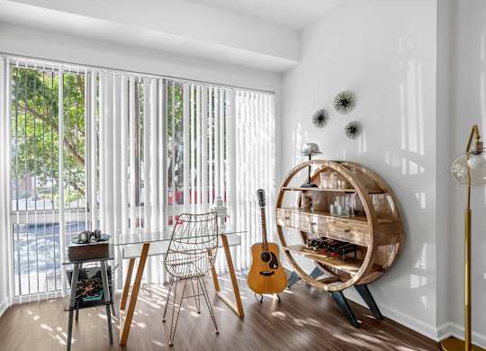 A room with a guitar and chair in it.
