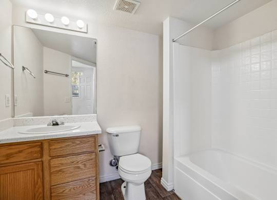 A white bathroom with a toilet, sink, and bathtub.