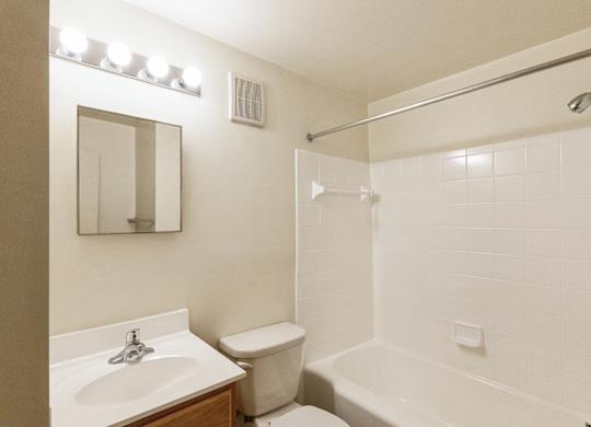 A white bathroom with a sink, toilet, and bathtub.