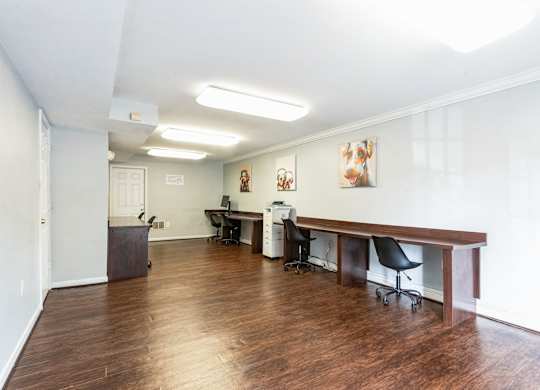 A room with a desk and chairs.