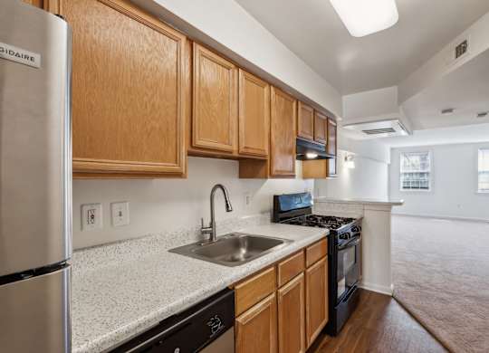 A kitchen with wooden cabinets and a stainless steel refrigerator.