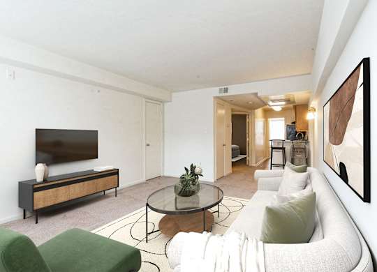 A living room with a white couch, a green chair, and a glass coffee table at The Fields of Bethesda, Chevy Chase, MD