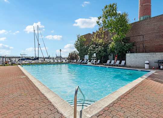 A large outdoor swimming pool with a brick border.