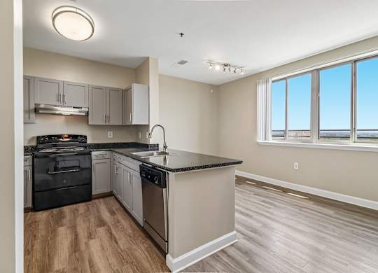 A kitchen with a black countertop and stainless steel appliances.