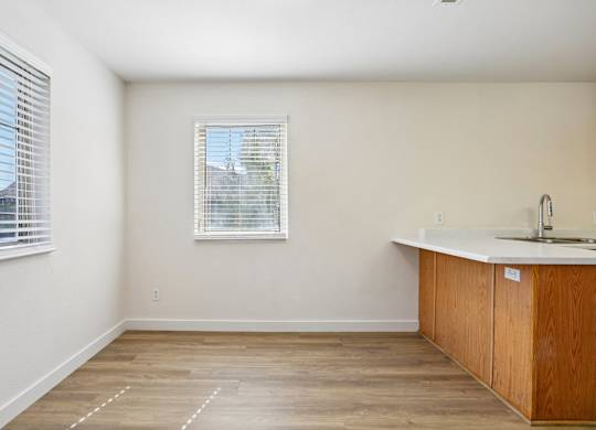 A kitchen with a window and wooden floors.