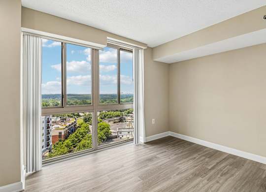 A room with a view of the city through large windows.