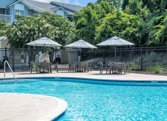 a swimming pool with patio furniture and umbrellas next to a resort style pool at St. Andrews Reserve, North Carolina, 28412