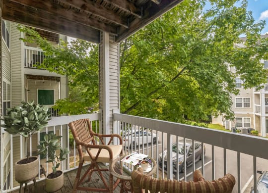 a porch with two chairs and a table on a balcony at Sanger Place, Lorton, VA