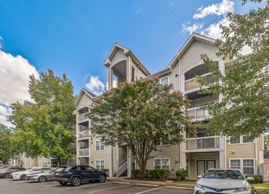 an apartment building with cars parked in front of it at Sanger Place, Lorton, VA