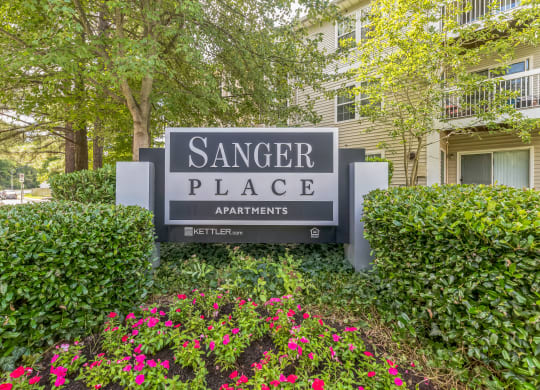 a sign for sangger place apartments in front of flowers at Sanger Place, Lorton, VA, 22079