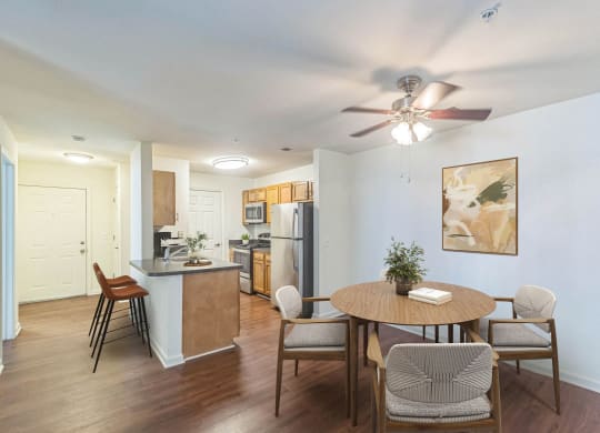 a living room with a dining room table and a kitchen at Sanger Place, Lorton, VA