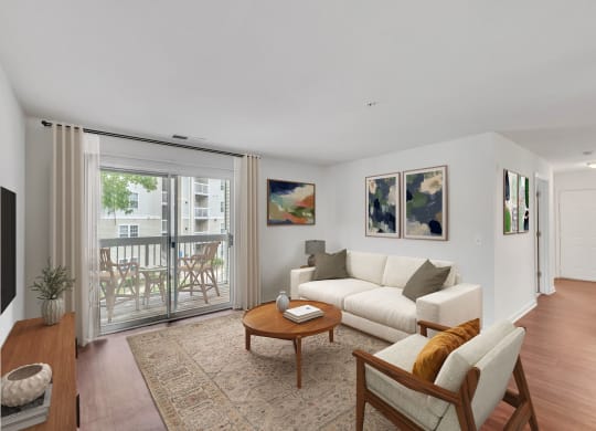 a living room with white furniture and a sliding glass door to a balcony at Sanger Place, Lorton, 22079