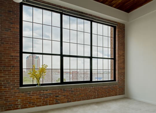 an empty room with a large window and a brick wall at Tindeco Wharf, Baltimore Maryland