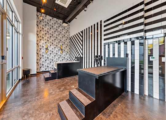 a lobby with stairs and a wall with black and white stripes
