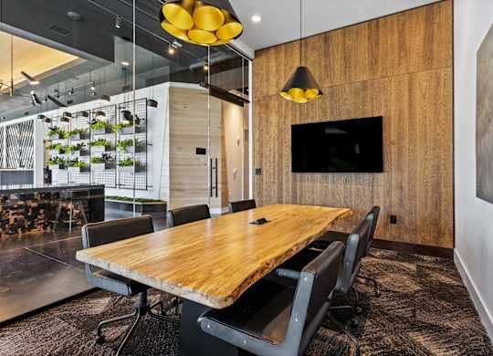 a conference room with a wooden table and chairs and a tv at South and Hollis, Charlotte, NC, 28209