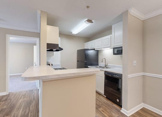 a kitchen with a large counter top and a black refrigerator at Alexander Ridge Apartments, Canton , GA