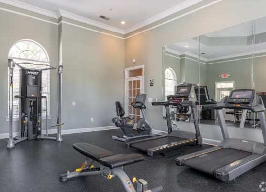 a gym with treadmills and other exercise equipment in the corner of a room at Alexander Ridge Apartments, Canton