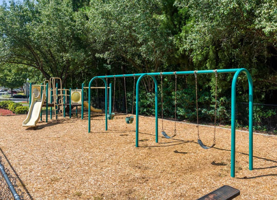 a playground with a swing set and other playground equipment at Alexander Ridge Apartments, Canton