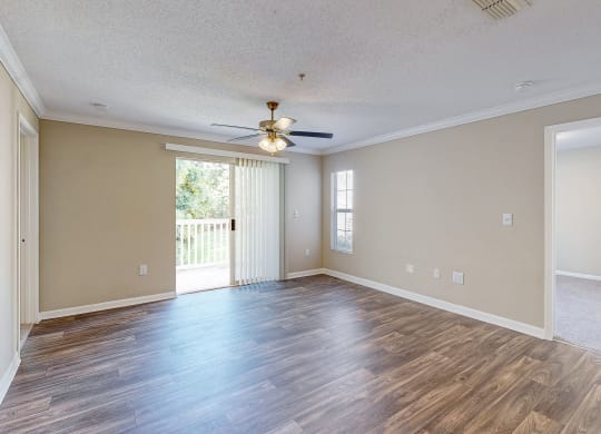 an empty living room with wood floors and a ceiling fan at Alexander Ridge Apartments, Canton , 30114