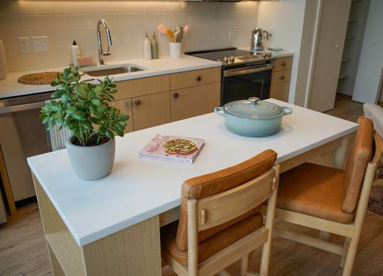 A kitchen with a table and chairs in the foreground.