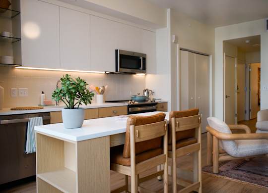 A kitchen with a table and chairs.