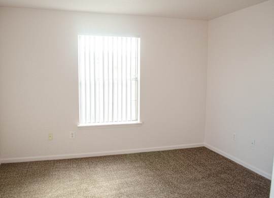 A room with a window and carpeted floor at Arrowhead Ridge Apartments, Rio Rancho, New Mexico