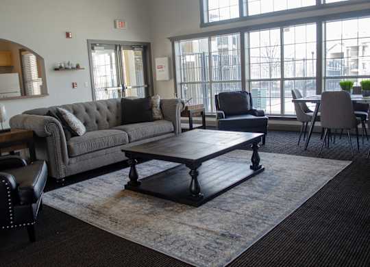 A grey couch with a black leather chair in front of it at Arrowhead Ridge Apartments, New Mexico