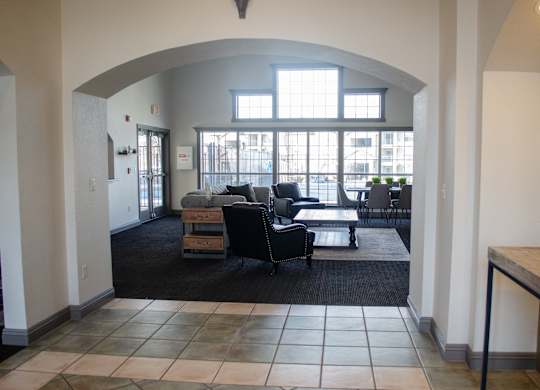 A large room with a black couch and a table at Arrowhead Ridge Apartments, New Mexico 87124