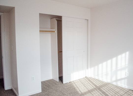 A white door is in a white room with a tan carpet at Arrowhead Ridge Apartments, Rio Rancho, NM
