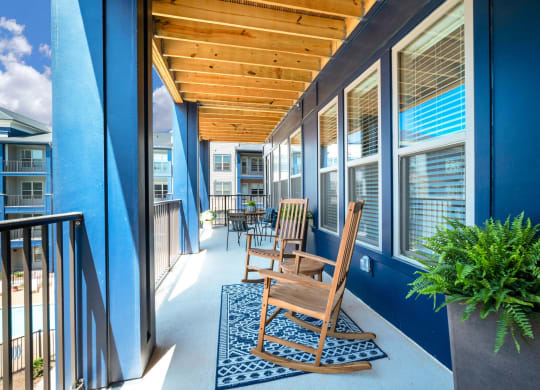 a porch with blue walls and a wooden rocking chair at Preston Ridge, Cary, 27513