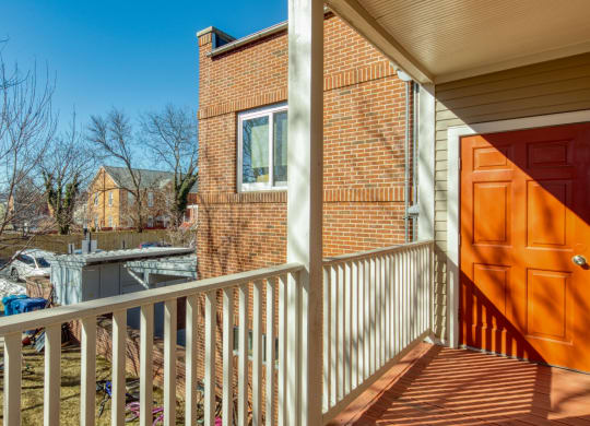 the front porch of a home with a wooden door and a balcony at North Market South Carroll, Frederick, 21701