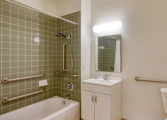 a bathroom with a tub sink and toilet and a mirror at North Market South Carroll, Frederick, MD 21701