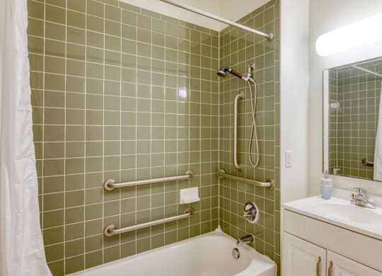 a green tiled bathroom with a tub and a sink at North Market South Carroll, Maryland