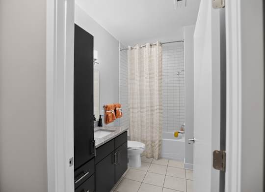 A bathroom with a white toilet and a shower with a white curtain.